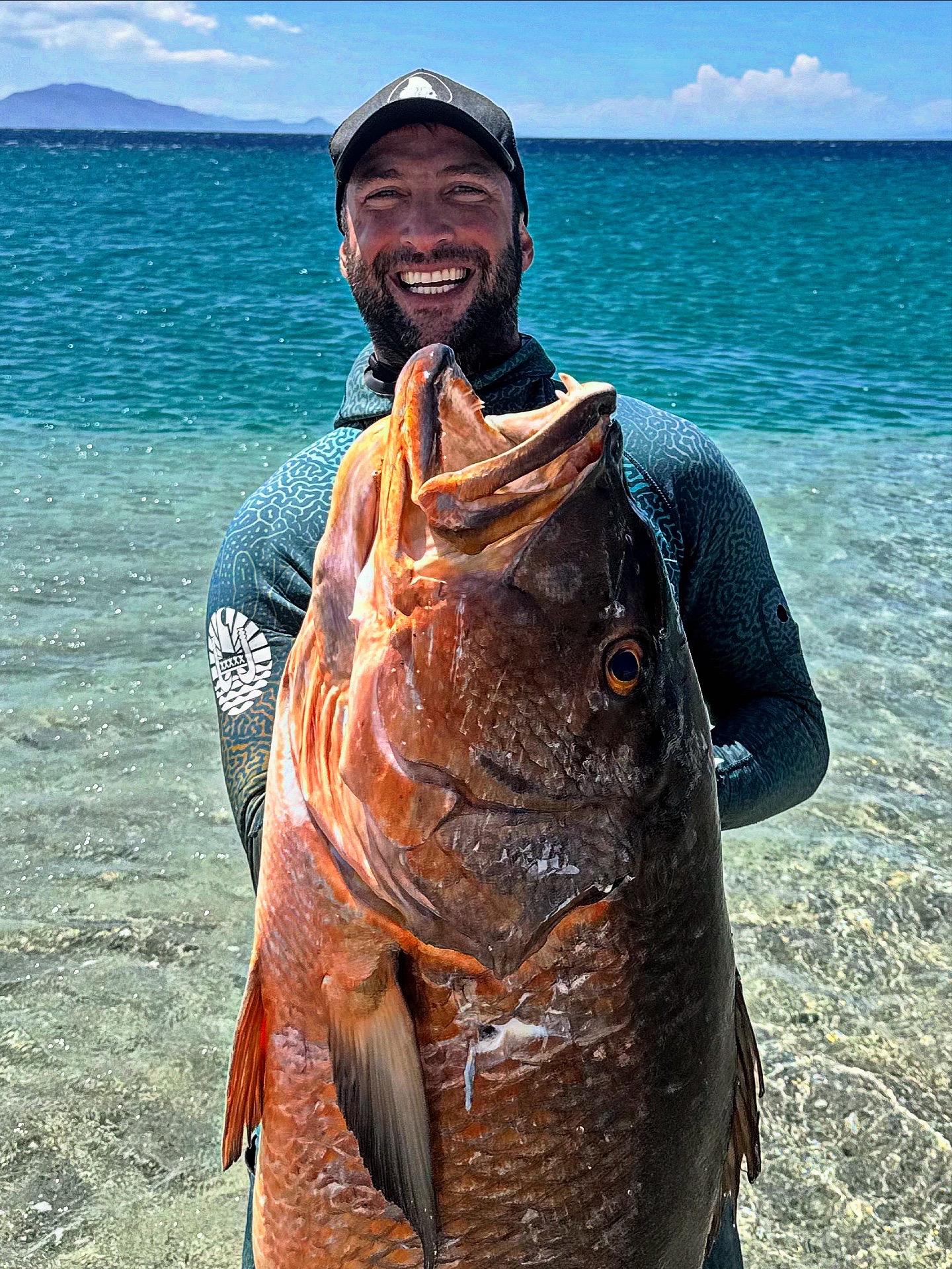 Francesco on the shoreline in Amed holding a large snapper