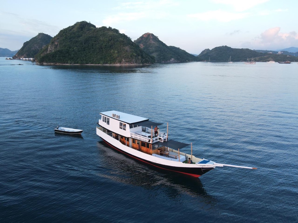 Boat anchored in a remote Indonesian bay at sunrise